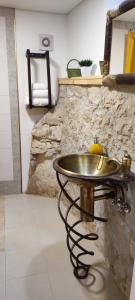 a metal sink in a room with a stone wall at Casa da Pedra - Alvados, Porto de Mós in Alvados