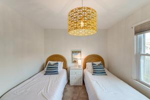 two beds in a room with a chandelier at Walk to Beach and Dtwn Dining! Avalon Coastal Escape in Avalon