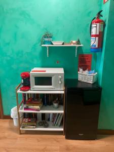 a microwave on a shelf next to a refrigerator at Hostal La Concha en Somo in Somo