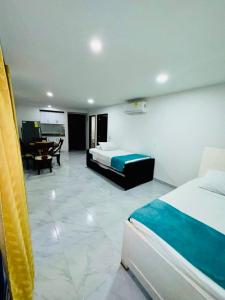 a bedroom with two beds and a dining room with a table at Apartamento remodelado cómodo y cerca al mar in Cartagena de Indias