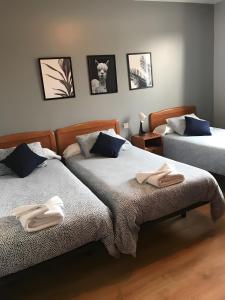 a bedroom with two beds with towels on them at Hostal La Concha en Somo in Somo