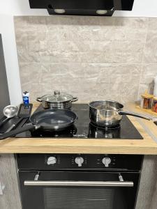 two pots and pans on a stove in a kitchen at Le Quatre in Avignon