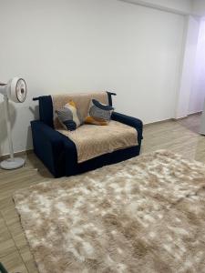 una sala de estar con un sofá y una alfombra en Entre Mar e Morros, Apto praia Pontal Recreio, en Río de Janeiro