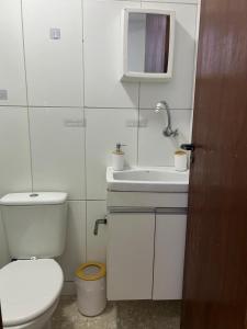 Un baño blanco con inodoro y lavabo. en Entre Mar e Morros, Apto praia Pontal Recreio, en Río de Janeiro