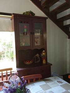 a dining room table with a hutch and a table at Hostel pousada floresta in Joinville +4 photos