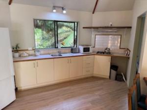 een lege keuken met een wastafel en een raam bij Fern Cottage in Mangonui