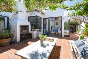 a patio with a fireplace in a house at Authentic Cape Dutch Gem - Relax & Unwind in Cape Town
