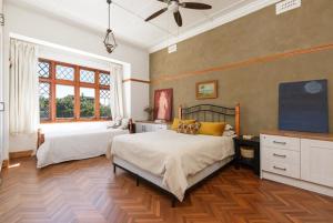 a bedroom with two beds and a large window at Authentic Cape Dutch Gem - Relax & Unwind in Cape Town