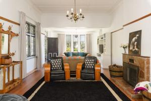 a living room with a couch and a table at Authentic Cape Dutch Gem - Relax & Unwind in Cape Town +4 photos