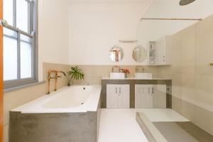 a large bathroom with a large tub and a sink at Authentic Cape Dutch Gem - Relax & Unwind in Cape Town