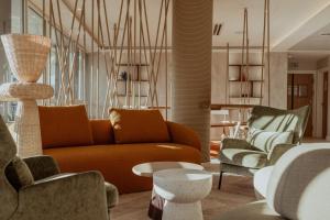 a living room with a couch and two chairs at Hotel Reva TAHITI in Papeete