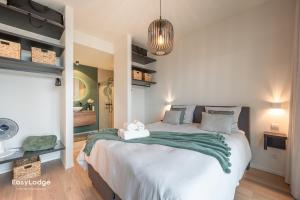 a bedroom with a large bed with a green blanket at FORTESSE - Luxury apartment near the sea with parking in Ostend