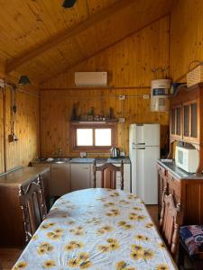 una cucina con tavolo e una cucina con pareti in legno di Olivillos II a Balneario Pehuén-Có