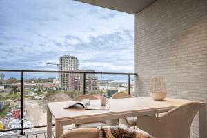a balcony with a table and a view of a city at FORTESSE - Luxury apartment near the sea with parking in Ostend +13 photos
