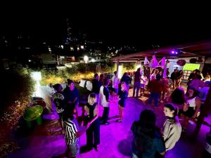 een groep mensen op een feest 's avonds bij Casa Angel Hostel in Oaxaca City