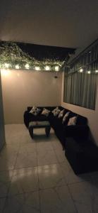 a living room with a black couch and lights at Hotel gym club33 in Huancayo