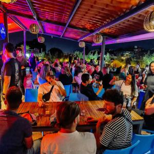 een menigte mensen die aan tafel zitten in een bar bij Casa Angel Hostel in Oaxaca City