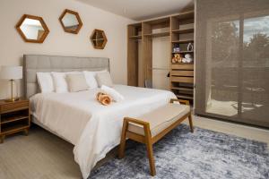 Cumbres Garden luxury apartments في كانكون: غرفة نوم بها سرير أبيض كبير ونافذة +49 صورة