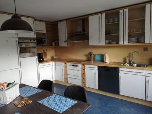 a kitchen with white cabinets and a table in it at Ferienwohnung "Tilda" auf Hof Elseblick in Bünde +12 photos
