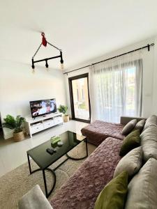 ein Wohnzimmer mit Sofa und Fernseher in der Unterkunft El Gouna -G-cribs B6 in El Gouna