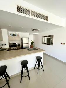 eine Küche mit zwei Barhockern und einer Arbeitsplatte in der Unterkunft El Gouna -G-cribs B6 in El Gouna