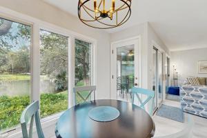 ein Esszimmer mit Tisch und Stühlen und Fenstern in der Unterkunft Turtle Cove 5529 in Kiawah Island