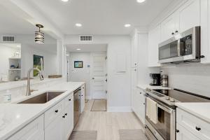 eine weiße Küche mit weißen Schränken und einer Spüle in der Unterkunft Turtle Cove 5529 in Kiawah Island + 16 Fotos