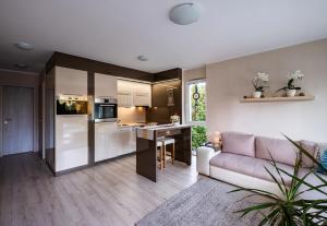 a living room with a couch and a kitchen at Kriszta Residence in Balatonalmádi