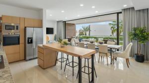 a kitchen and dining room with a table and chairs at Modern Condo with Stunning Bay Views in Cabo San Lucas