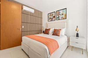 a bedroom with a large bed with an orange blanket at Modern Condo with Stunning Bay Views in Cabo San Lucas +42 photos