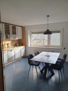 a kitchen with a table and chairs and a window at Ferienwohnung "Tilda" auf Hof Elseblick in Bünde