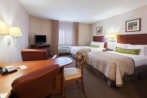 una camera d'albergo con due letti e una scrivania di Candlewood Suites - Texas City by IHG a Texas City