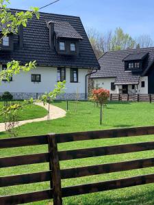 普利特维采村Plitvice Falls Cottage - Luxury rooms & Dinner的院子前有围栏的房子