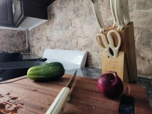 a kitchen counter with a cutting board and a knife and a cucumber at Hilltop Villa Chez Coco in Rodney Bay Village +4 photos