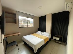 a small bedroom with a bed and a window at Hotel Escorial Ibagué in Ibagué