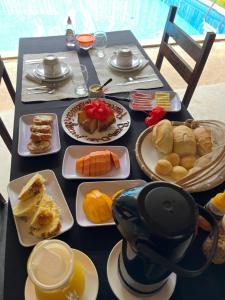 a black table with plates of food on it at Eco Pousada Mentawai in Itacaré