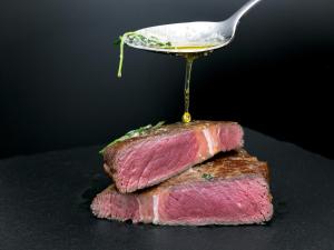 una cuchara con aceite encima de un trozo de carne en Das Hotel by Ferber, en Monheim