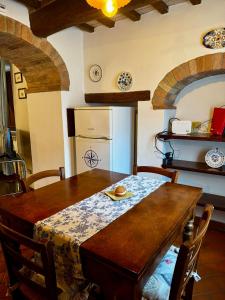 a kitchen with a wooden table and a refrigerator at Appartamento Kira in Porrona +19 photos