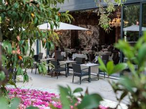 a restaurant with tables and chairs and flowers at Papadopoli Hotel Venezia - MGallery Collection in Venice