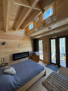 a bedroom with a bed and a wooden wall at Refuge Fristad - Microchalet Peppar avec spa privé in Saint-Calixte