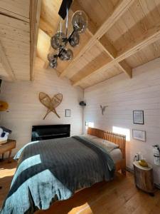 a bedroom with a bed in a room with wooden ceilings at Refuge Fristad - Microchalet Peppar avec spa privé in Saint-Calixte +15 photos
