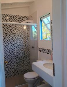 a bathroom with a toilet and a sink and a shower at Camburizinho Casa em condomínio a 250m da praia in São Sebastião +9 photos