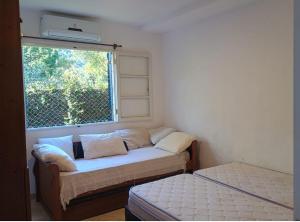 a small room with a couch and a window at Camburizinho Casa em condomínio a 250m da praia in São Sebastião