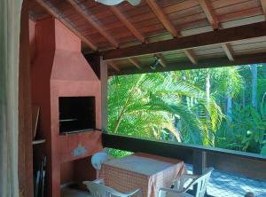 a patio with a table and chairs on a porch at Camburizinho Casa em condomínio a 250m da praia in São Sebastião