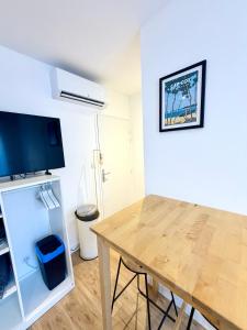 ein Esszimmer mit Tisch und Kühlschrank in der Unterkunft Appartements meublés Brest centre in Brest + 23 Fotos