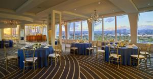 un salón de banquetes con mesas y sillas azules y ventanas en Cameo Beverly Hills, en Los Ángeles