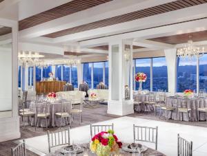 Un salón de baile con mesas, sillas y candelabros. en Cameo Beverly Hills, en Los Ángeles 113 fotos más