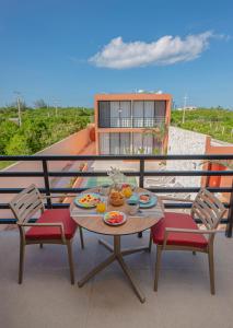 a table and chairs on a balcony with the beach at The Retreat at Sisal in Sisal