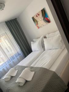 a bedroom with a bed with two white pillows at Ama Studio in Buşteni