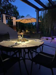 普利特维采村Plitvice Falls Cottage - Luxury rooms & Dinner的露台上的桌子和遮阳伞